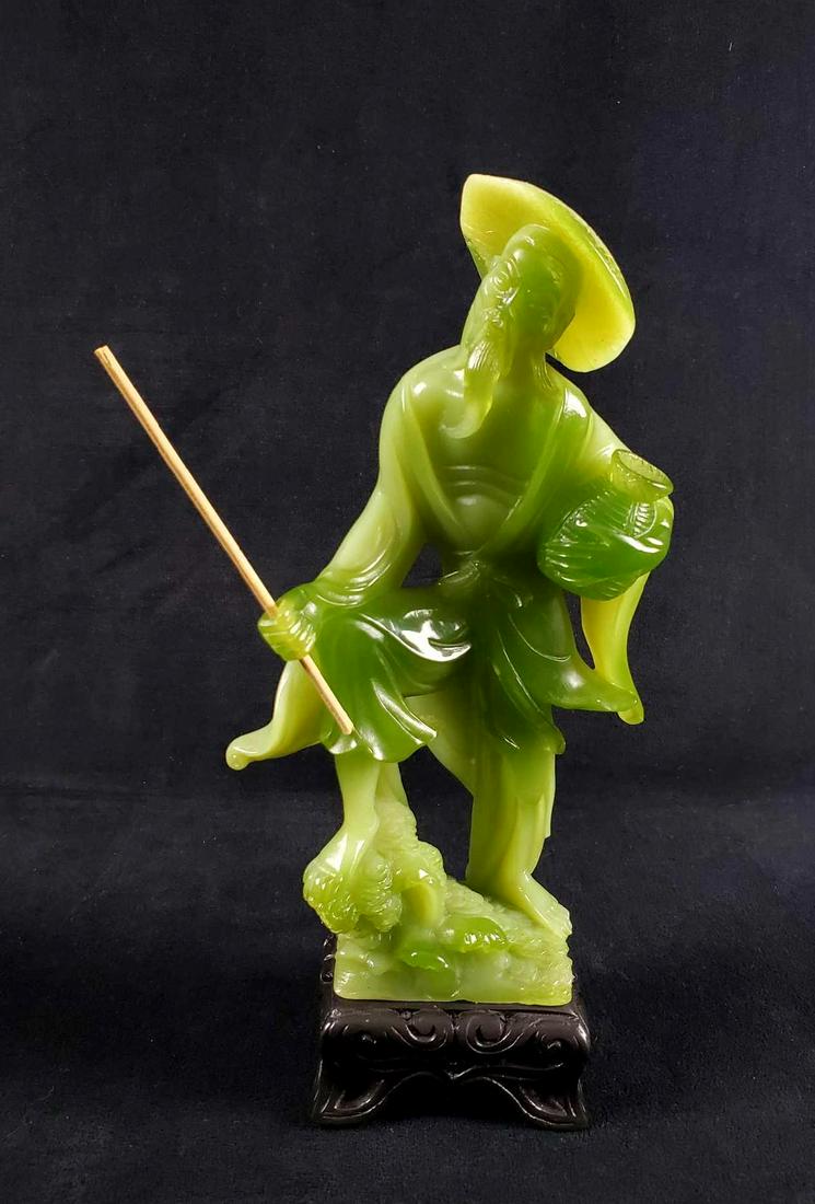 Carved Serpentine Jade Oriental Man on Pedastal: This is a carved serpentine jade sculpture of an Asian man with a conical hat, wooden staff and vase on a black carved wooden pedestal. 19th century. The green jade is translucent with various lighter