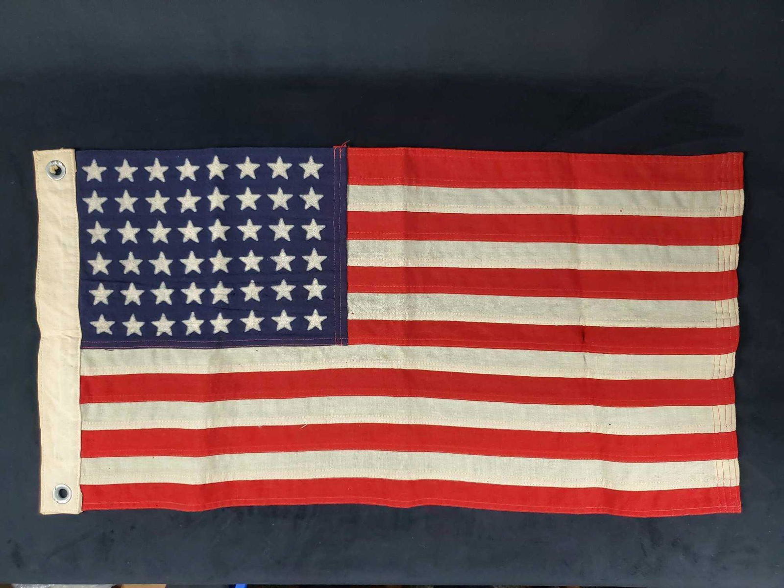 48 Star American Flag 1942: 48 Star American flag is in good used condition with some small holes in various places on flag. Â The flag in is a plastic bag and comes with a box.Â Stamped on the flag is U.S. No 12 MI 44. Acco