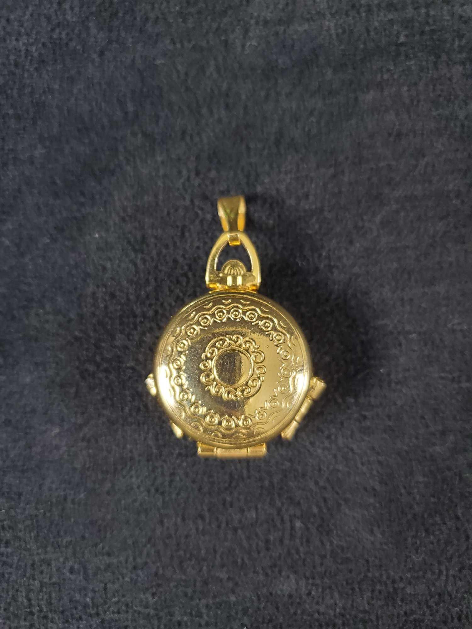Vintage Ornate 4 Chamber Locket Pendant: The locket features gold tone metal with ornate detailing and can display as many as 4 photographs. . Made by an unknown manufacturer. It is in good used condition with some scuffs and the picture sea