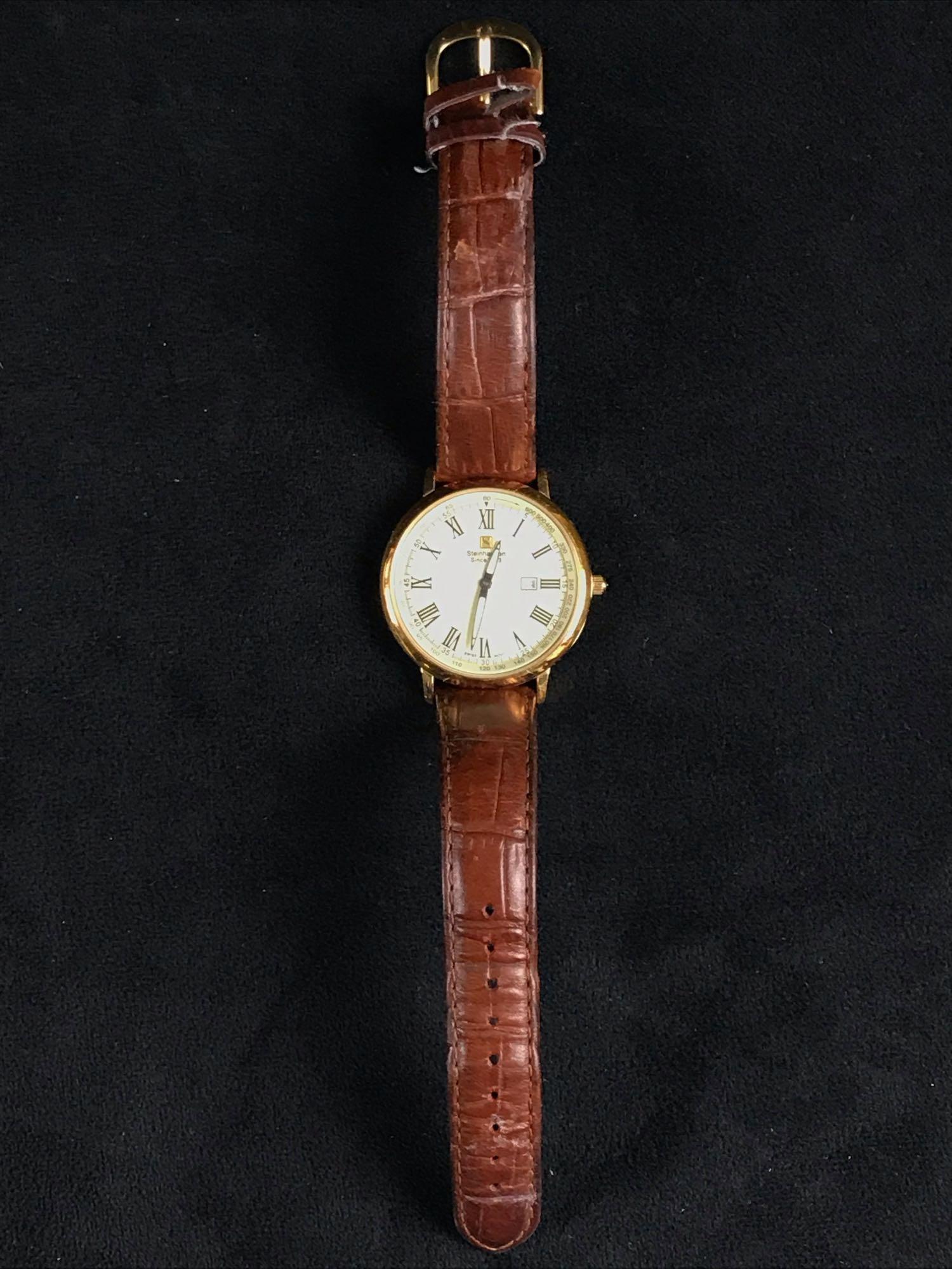 Steinhausen Mens Dunn Analog Thin Gold Calender Watch: ThisÂ Steinhausen Men's Dunn Analog Thin Gold Calender Watch with genuine leather strap is in great used condition with a very minor scratch on face (does not show up in an image). Swiss design and 