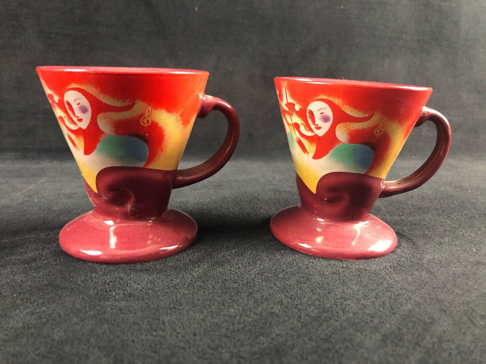 Pair of Vintage Frangelico Liqueur Mugs Coffee Cup Set: Pair of Vintage Frangelico Liqueur Mugs Coffee Cup Set Linda Frichtel Art French 1999 This lot features two Linda Frichtel 1999 liqueur mugs. The cups are hand-painted with a jester playing an instrum