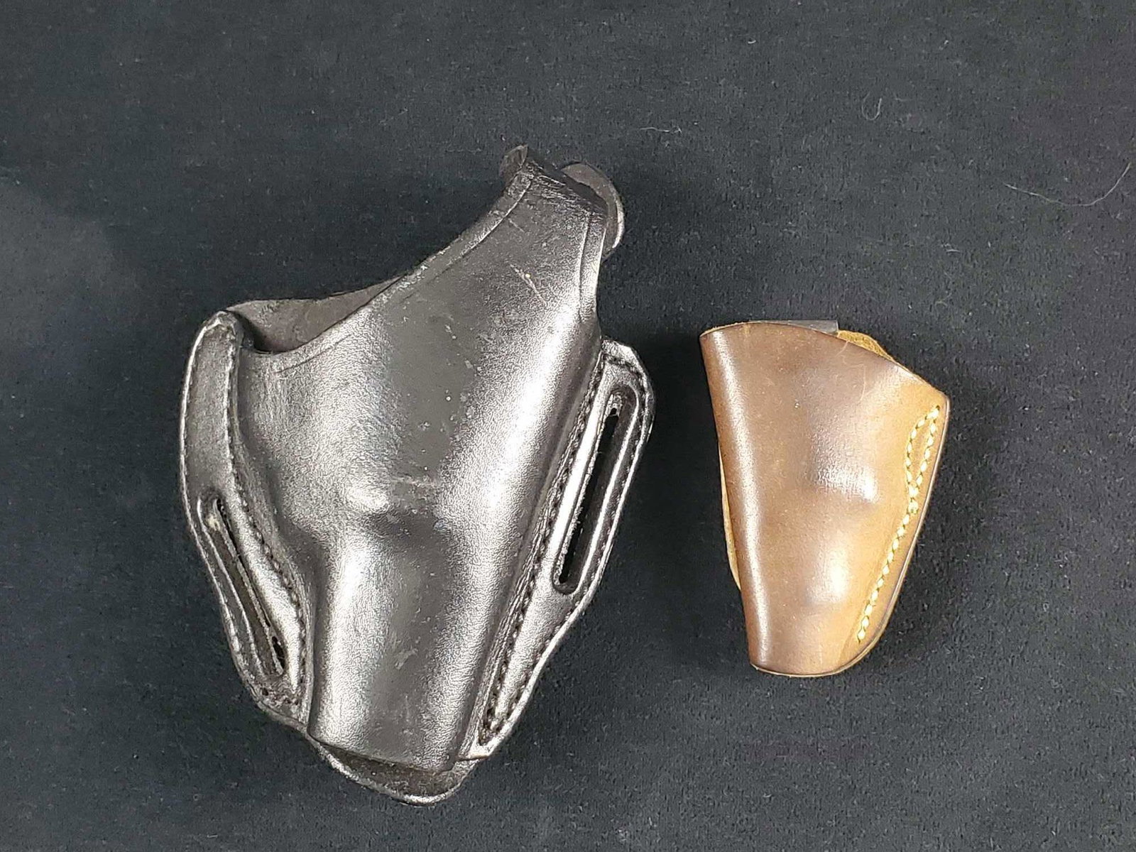 Vintage Leather Gun Holster Lot Of Two Brown Black: This lot includes: (1) Mini .22 Leather Derringer Holster With Belt Clip By North American Arms. Approx 3" x 1" x 3 1/2". Holster is in good, vintage condition with wearing to the left side. Stamped o
