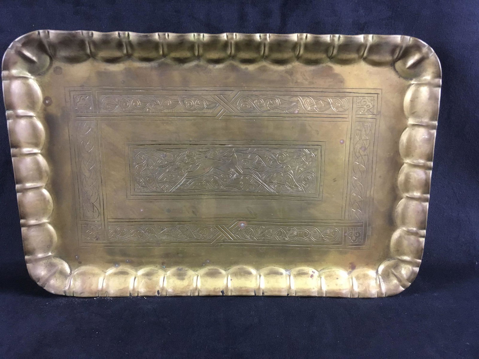Vintage Hand-tooled Brass Tray: Vintage Hand-tooled Brass Tray; the tray shows an intricate design with a sleek forest antelope. It is in good condition showing some small spots of tarnish. It measures 11" W x 17" L x 1" D.