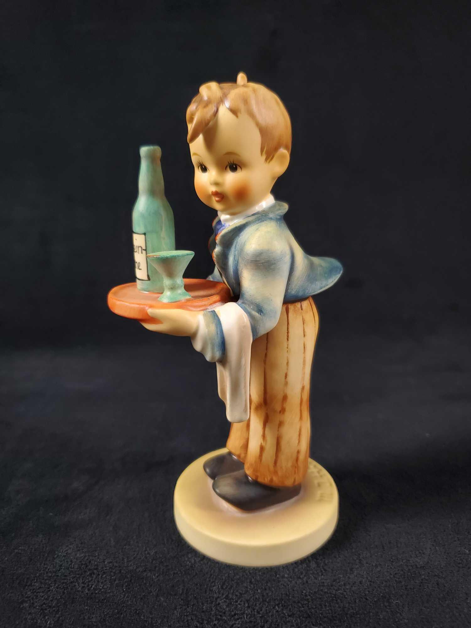 Hummel Goebel Figurine Waiter HUM 154: Bavarian boy offers only the finest of Rhein Wine, which is usually served in the West of Germany. The figure is in good, vintage condition with only some minor scuffs/wearing on the base of the figur