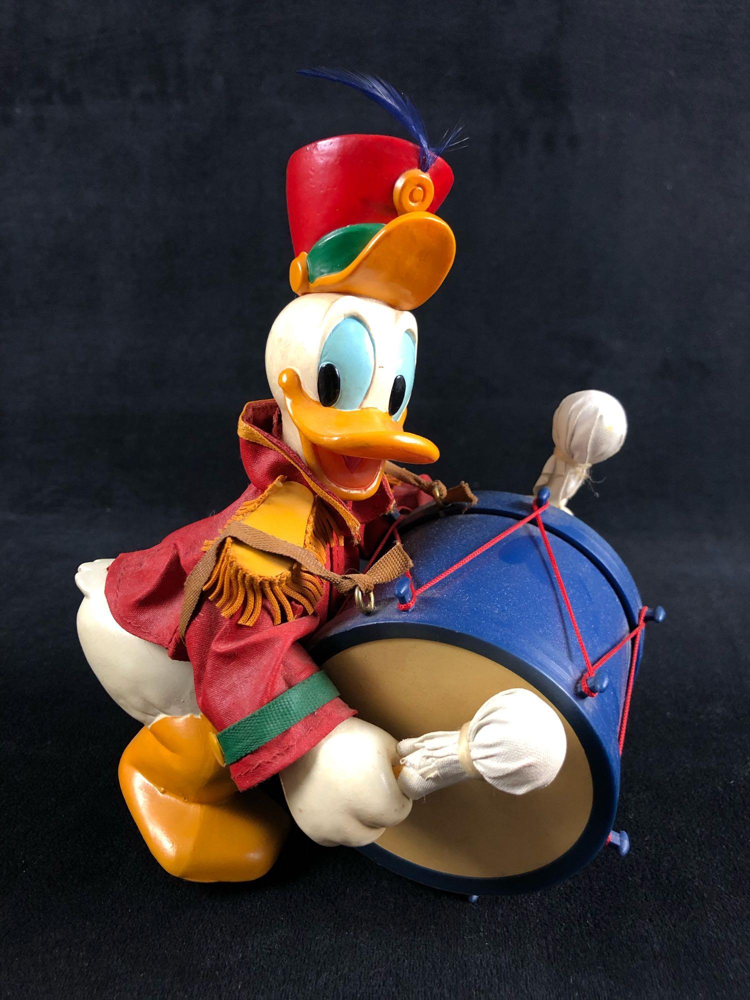 Vintage Donald Duck Marching Band Drummer Figurine Walt: Vintage Donald Duck Marching Band Drummer Figurine Walt Disney Company Painted sculpted figure of Donald Duck playing a drum by Fabriche KSA Collectibles. The drum is made of plastic with red thread, 