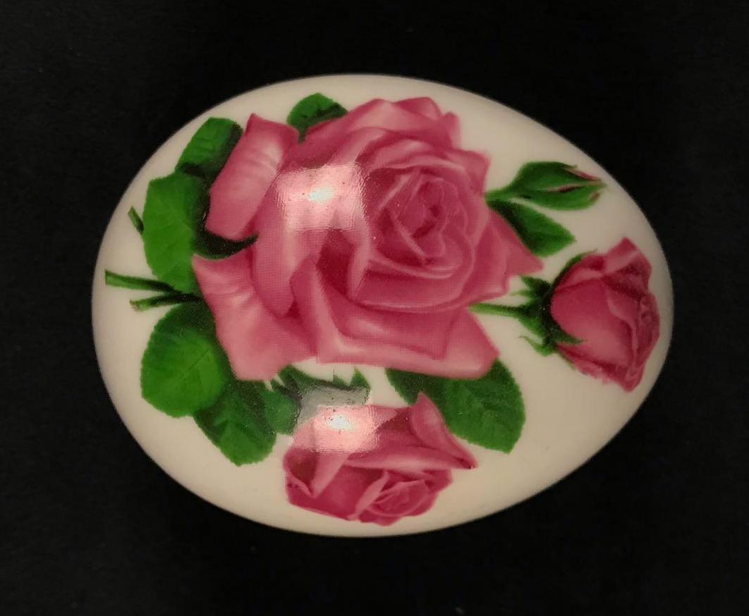 The Danbury Mint Porcelain Egg Trinket Box: The Danbury Mint Porcelain Egg Trinket Box. This porcelain box is in excellent condition. There are no chips or cracks in the porcelain. The egg box has a rose design on it. Maker's mark is on the bot