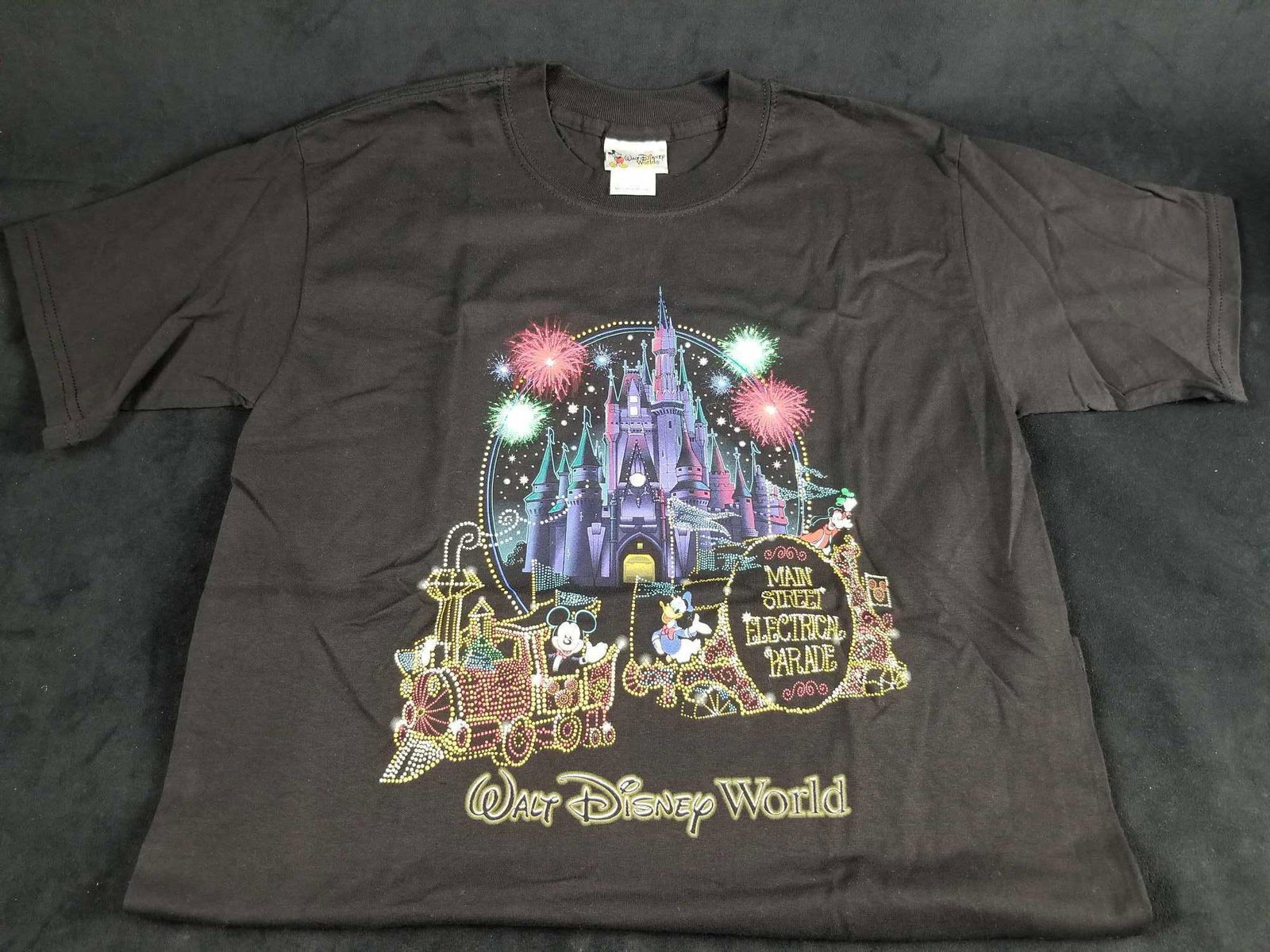Walt Disney World Main Street Electrical Parade Size S: This Walt Disney World "Main Street Electrical Parade" Cotton crew neck T-Shirt. This T-shirt displays Cinderella's castle with fireworks in display. This shirt has a neat textural element with added 