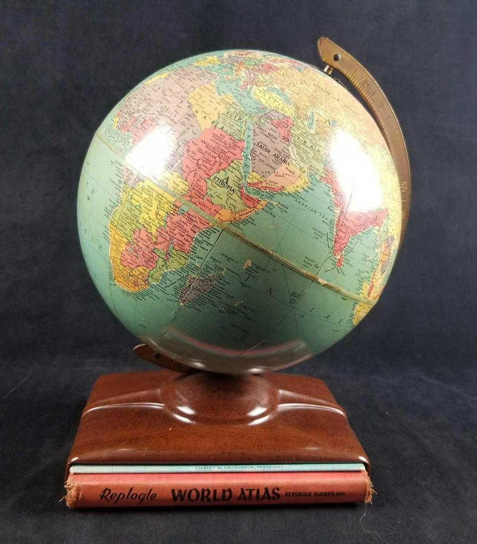 1950s Replogle World Globe with Original Atlas and Map: This 1950's World Globe from Replogle Globes INC comes with an Original Atlas and Map in the metal base. The Globe is in good used condition with some minor chips (see image). The rotating globe measu
