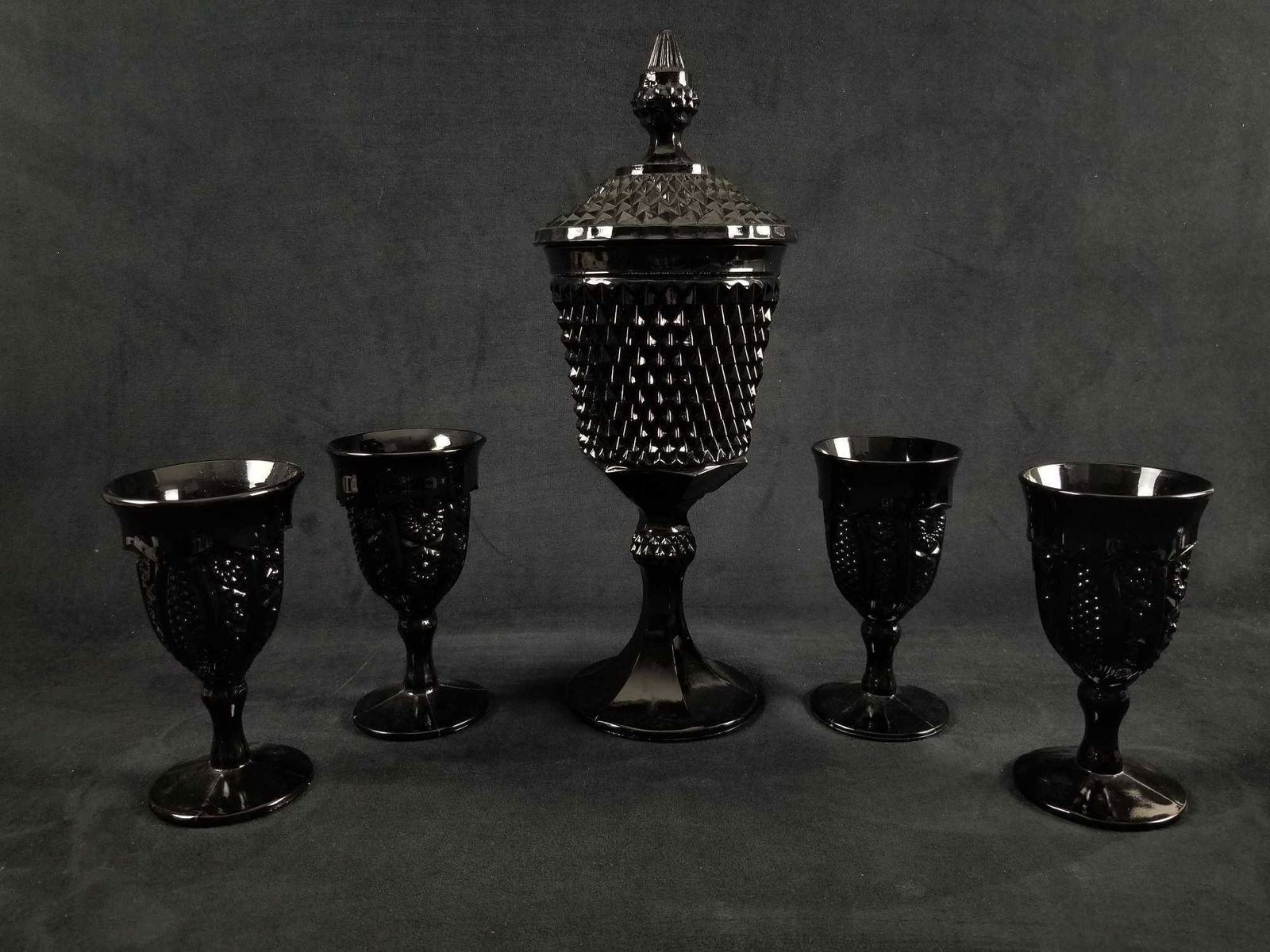 Vintage Tiara Indiana Glass Ebony Black Diamond Wine: Tiara Glass was marketed by Tiara Exclusives of Dunkirk, Indiana, USA through home-parties held by sales agents, between 1970 and 1998. Wine glasses are approx 3" x 6" and the jar is approx 4" x 16".