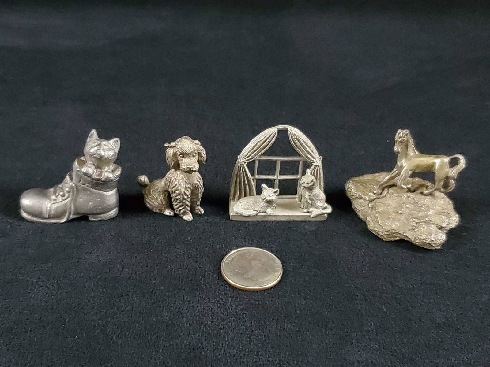4 Handcrafted Pewter Animals Lot: These four pewter animals consists of a poodle, a kitten in boots, 2 cats on a window sil, and a horse. The pieces are in good condition with some scratches. The horse however is bent and the back leg