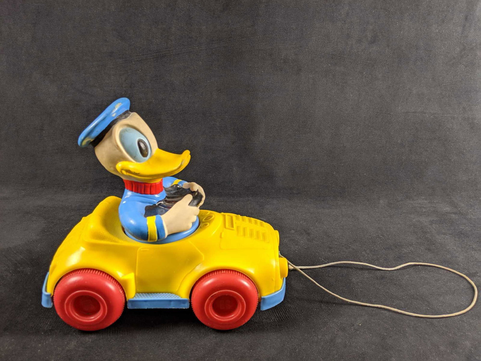 Vintage Donald Duck Pull Car Toy 1973: Vintage pull car toy from 1973. Made by the Kohner Toy Company. Made with brightly colored heavy plastic. Toy is in good, vintage condition with scuffs and scratches on Donald's hat. Colors are still