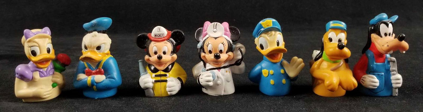 Lot Of Seven Vintage Rubber Disney Charcter Finger: This lot includes: Mail-Dog Pluto, Fire Mouse Mickey, Doctor Minnie Mouse, Handy-Goofy, Painter Daisy, Officer Donald Duck, And Grumpy Donald Duck. All are in good vintage condition, and some feel a l