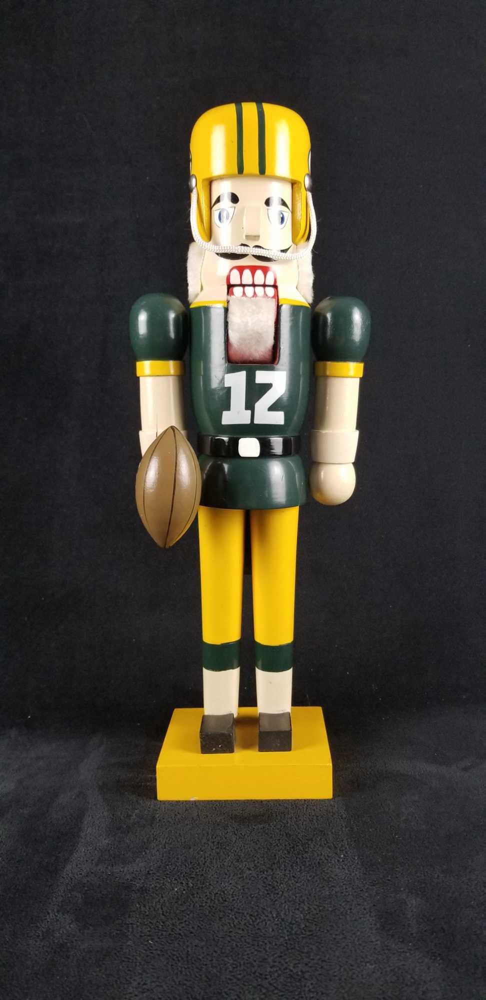 NFL Football Green Bay Pakckers Christmas Nutcracker: Papel NFL Green Bay Packers Christmas Nutcracker. Wooden with classic Packers colors and the number 12 painted on it. Fitted with players helmet and ball. Comes on a square base. Has official NFL logo