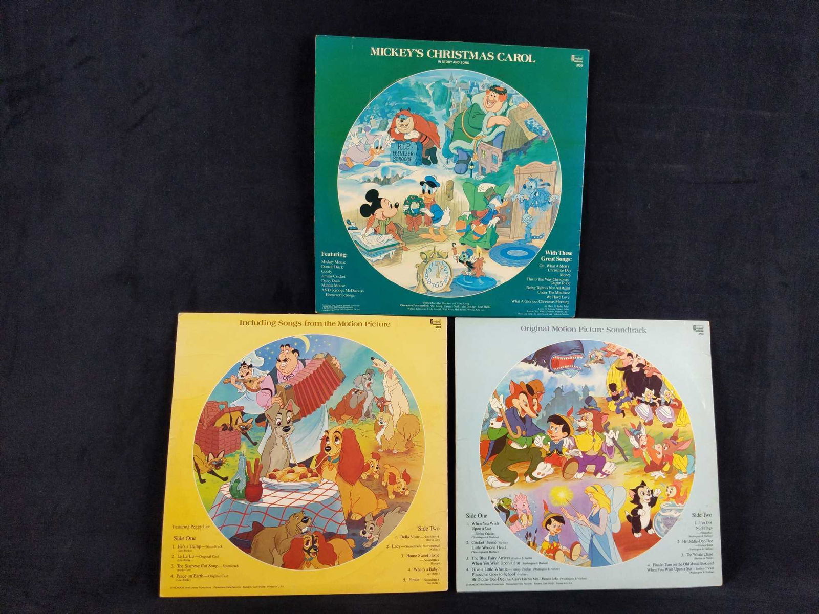 Disney Picture Disc LP Pinocchio Lady Tramp Christmas: Produced in the 1980s by Disney Records, these were Disney soundtrack LPs that feature images from the movie. This lot includes: (1) Pinocchio. Some discoloration on side 1 LP. (1) Lady & The Tramp. S