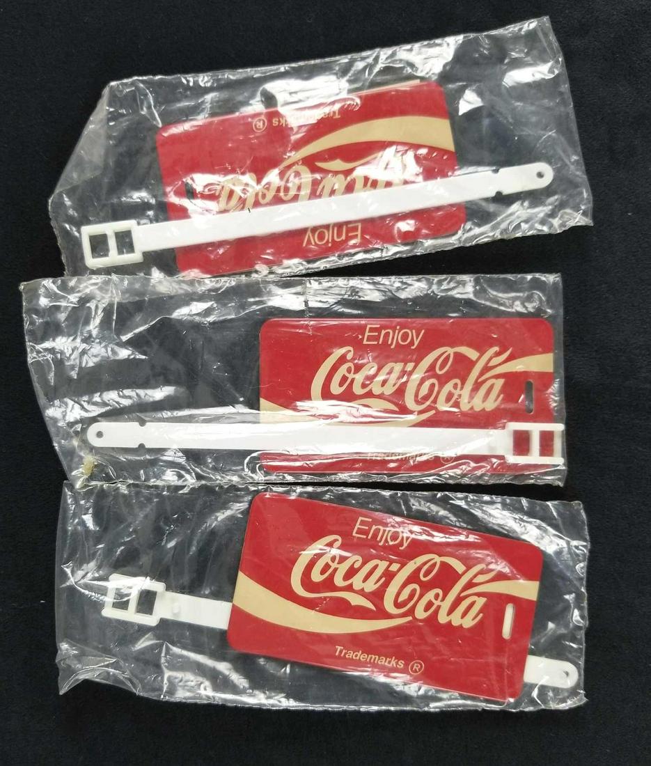 Lot of 3 Vintage Circa 1990s Coca Cola Luggage Tags: This lot consists of three Coca-Cola circa 1990s luggage tags. They appear vintage due to the design. They are in good condition with some known discoloration. Approximate measurement: Inside packagin