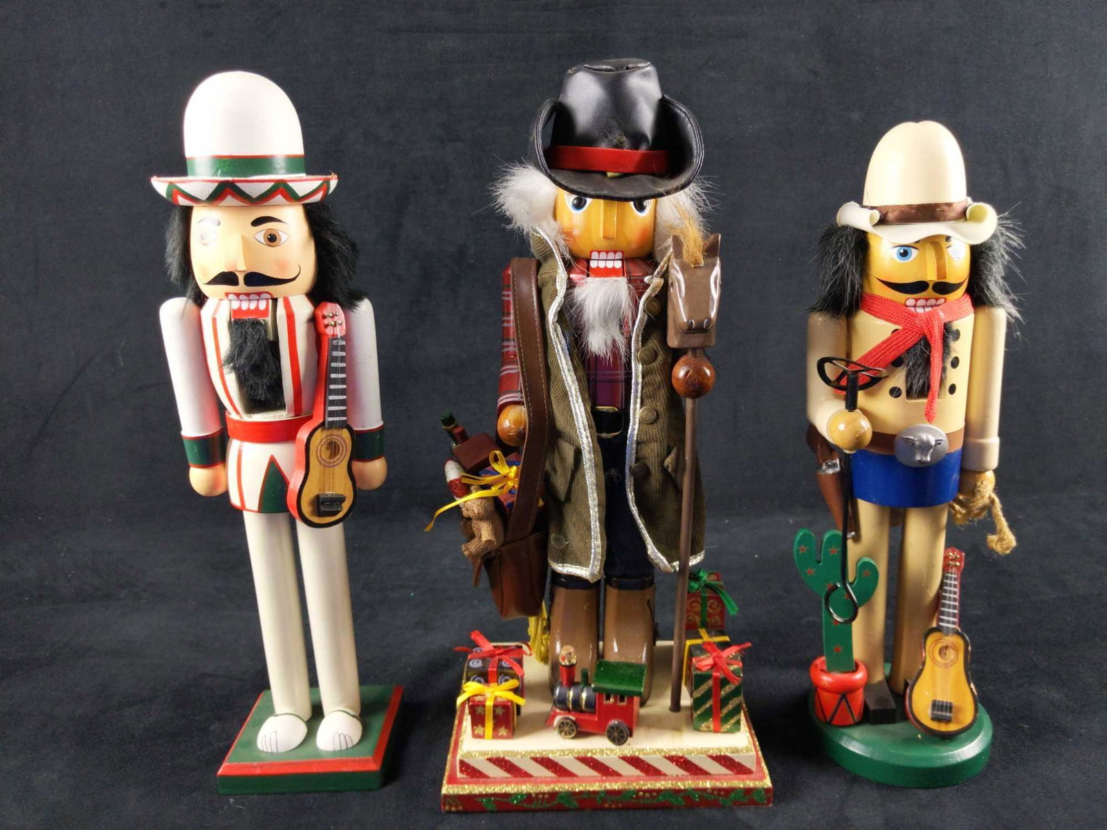 Three Wooden Western Cowboy Themed Nutcrackers: Hey Howdy Hey! These are three of the most rootiest tootiest nutcrackers in the west! This lot consists of: (1) Cowboy Santa Claus Wooden Nutcracker. This Cowboy-Claus isn't packing heat, but gifts! W