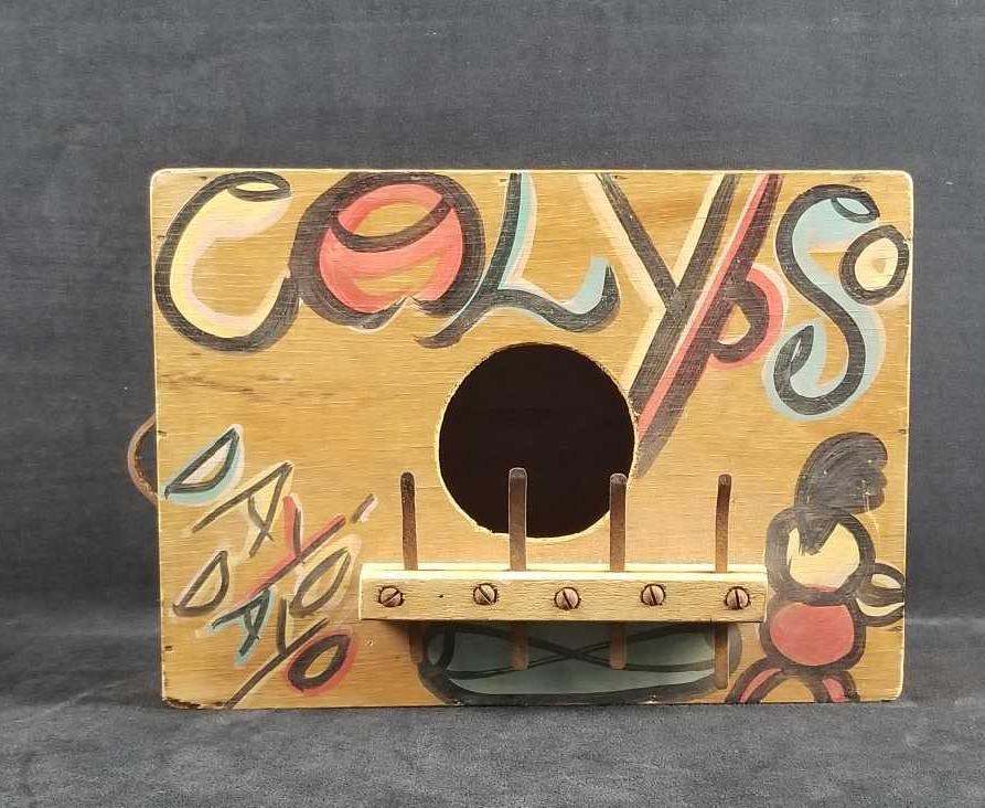 Vintage Jamaican Rumba Music Box: Vintage Jamaican Rumba music box is wooden and hand painted. The metal prongs extend over the opening and when plucked the music begins. It is in good used condition with a leather strap for carry. It