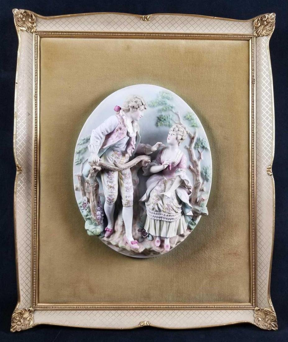 Vintage Bisque Relief Wall Plaque As IS: Vintage Bisque Relief Wall Plaque. This highly detailed and beautifully painted piece depicts lovers from Victorian Era. This porcelain piece is mounted on a light brown fabric board and framed with g