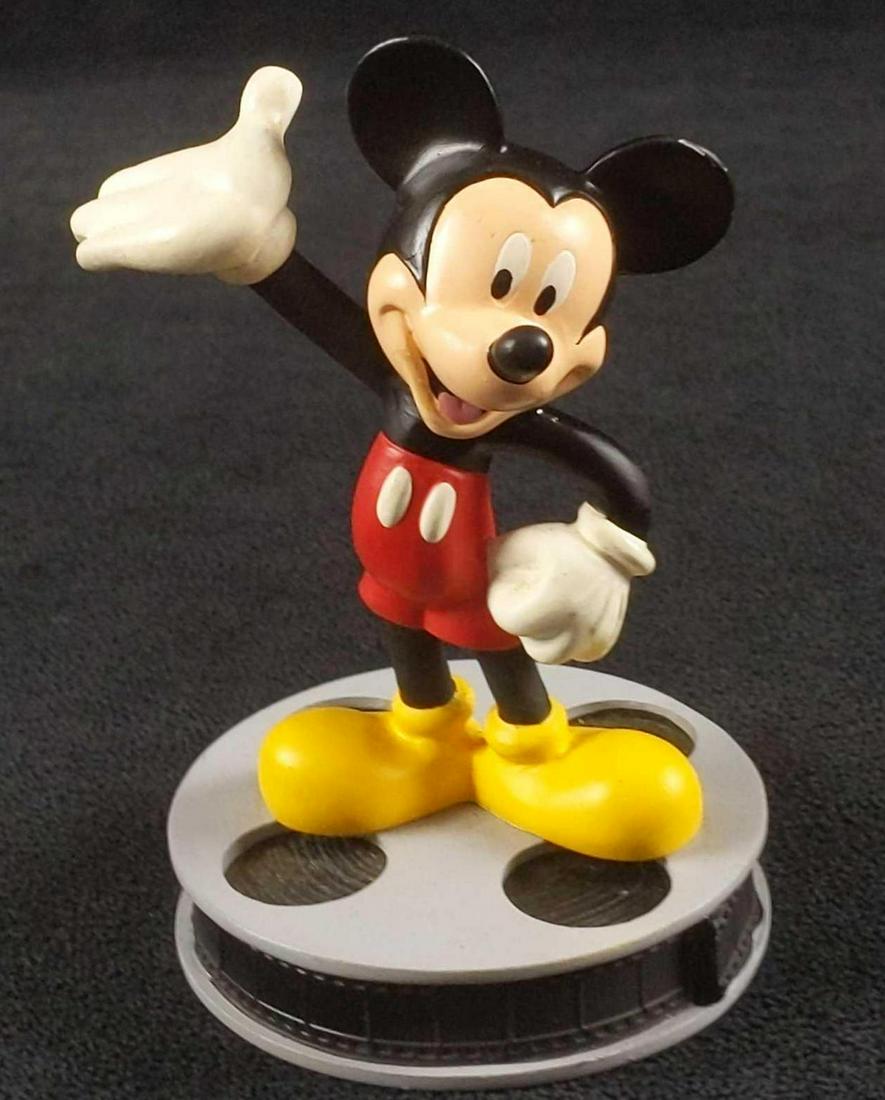 Disney Mickey Mouse Figurine On Movie Reel: Mickey Mouse On A Film Reel by Applause. Figurine is approx 3" x 3" x 4 1/2". Figure is in good, used condition with some wear on Mickey's face and a small white mark on Mickey's left ear. Figurine wo
