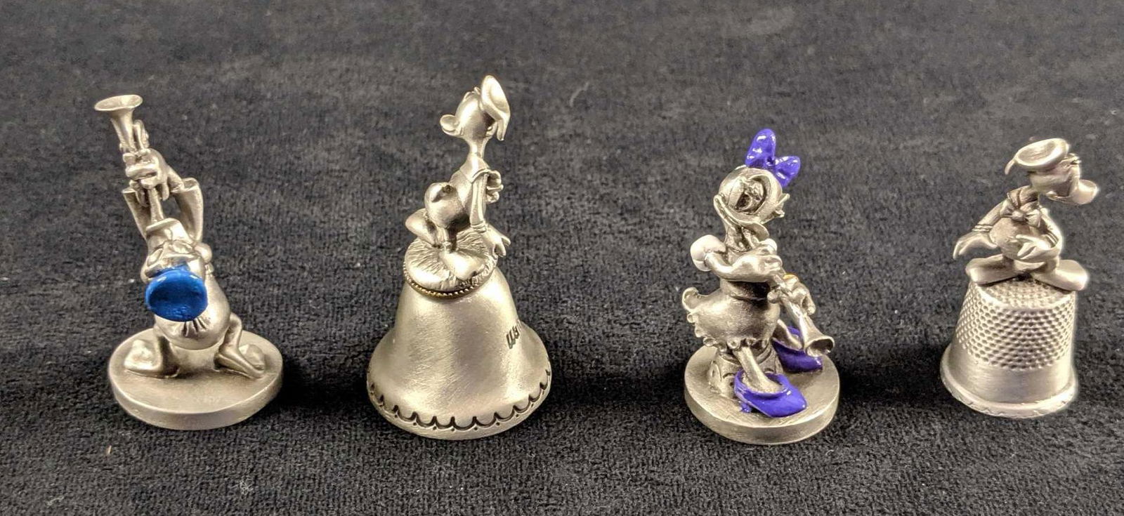 Lot Of Four Disney Donald Duck Pewter Mini Figures: This is for four Donald Duck pewter figures. This includes: Walt Disney World Bell, Donald on an thimble. Hudson Donald Duck blowing a horn with painted hat.And Hudson Daisy Duck playing horn. Her bow