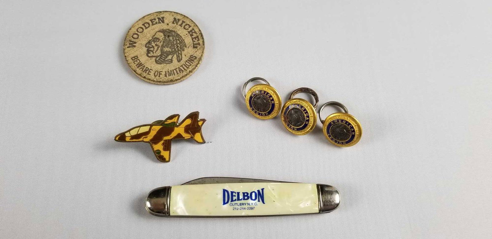 Assorted Lot of 6 Pocket Knife 1919 American Legion: This lot contains: 3- 1919 American Legion buttons Approx. measure 1/2" 1-Imperial Prov. RI USA pocket knife with white handle, "Delbon Cutlery NYC" inscribed on handle. Knife has bottle opener and ha
