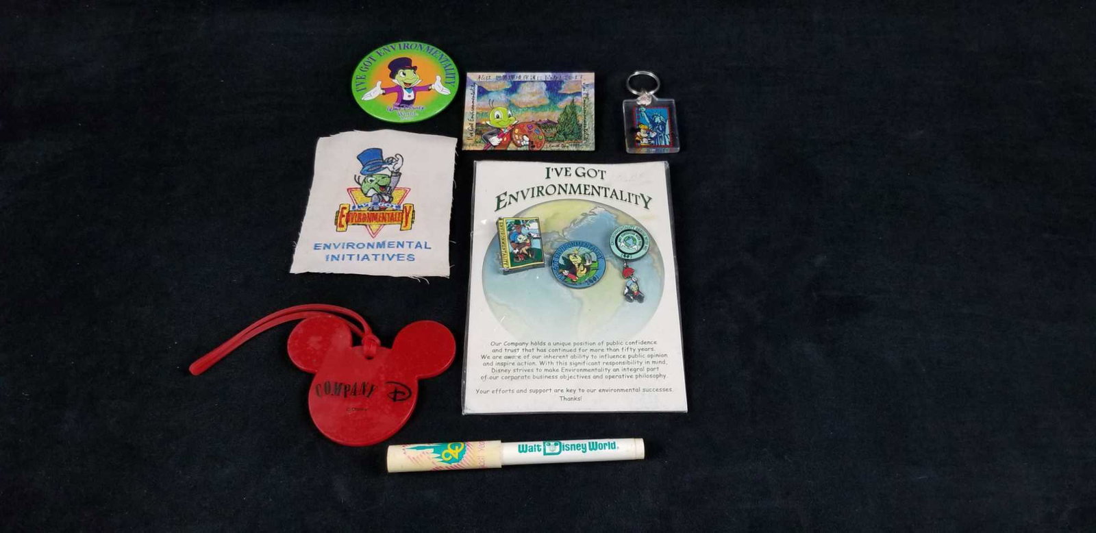 Jiminy Crickey Walt Disney World Pins and Trinkets: This lot contains: 1- "I've Got Environmentality" Jiminy Cricket package containing 3 pins, one is from 2001, 2003, and the other is not dated 1- Red plastic Mickey Mouse luggage ID 1- Environmental i