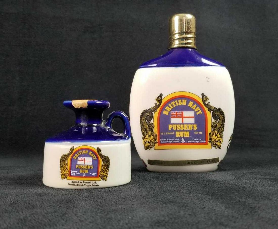 Britsh Navy Pussers Rum Decanter Bottles: This lot contains Britsh Navy Pusser's Rum porcelain bottle and flask. The flask has a screw top and the back has the Royal Nay Rum Terminology on the back. The bottle has a cork stopper. Both are emp