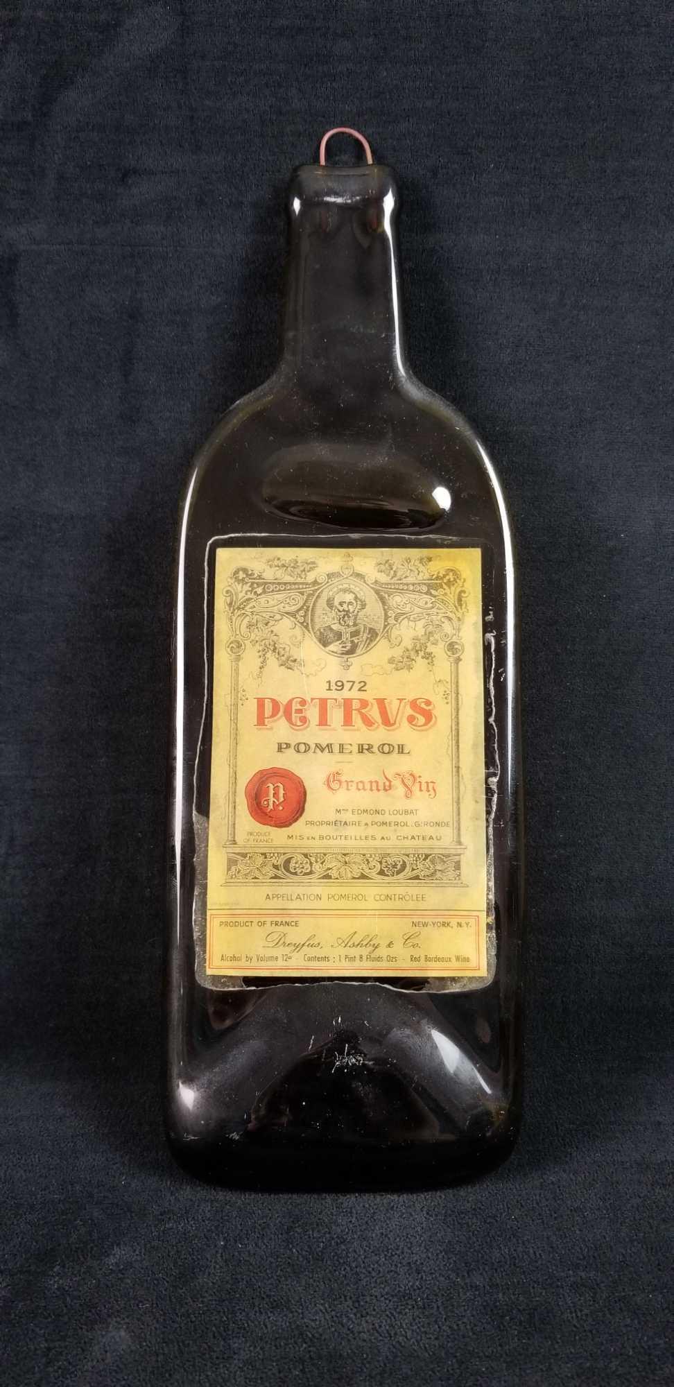 Petrus Pomerol Grand Gin Flattened Bottle: 1972 Vintage Petrus Pomerol Grand Yin Flattened Bottle. Bottle in good condition the label adhesive is loose in areas. Has a metal hook for hanging. Approx. measures 4 1/2" x 14" 1/2"