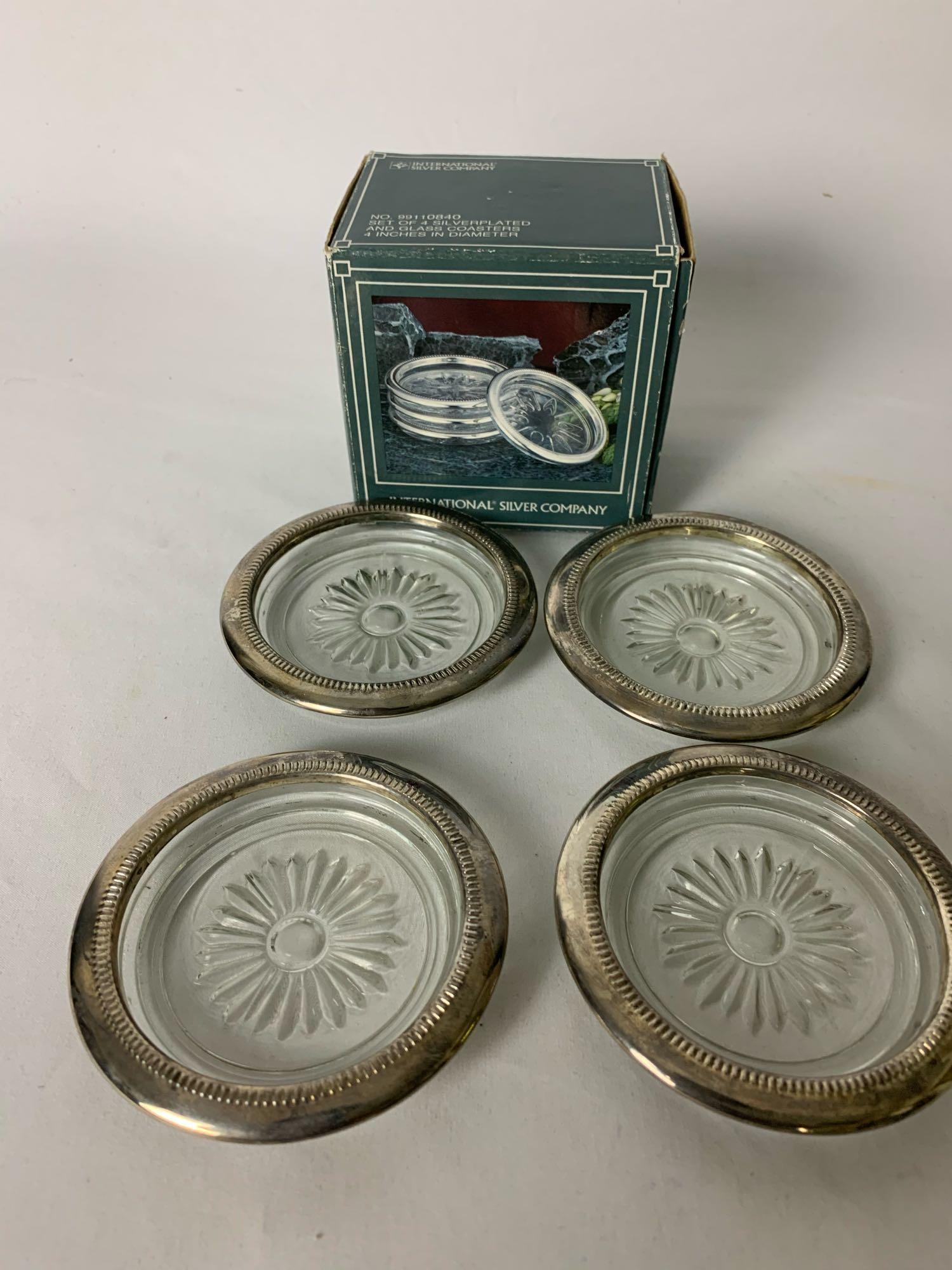 International Silver Company 4 Silverplated Coasters: International Silver Company 4 Silverplated Coasters Glass base and silverplated rings around coaster. Condition: All 4 coasters Good. Outer boc has some fading, please see photos. Actual coasters sho