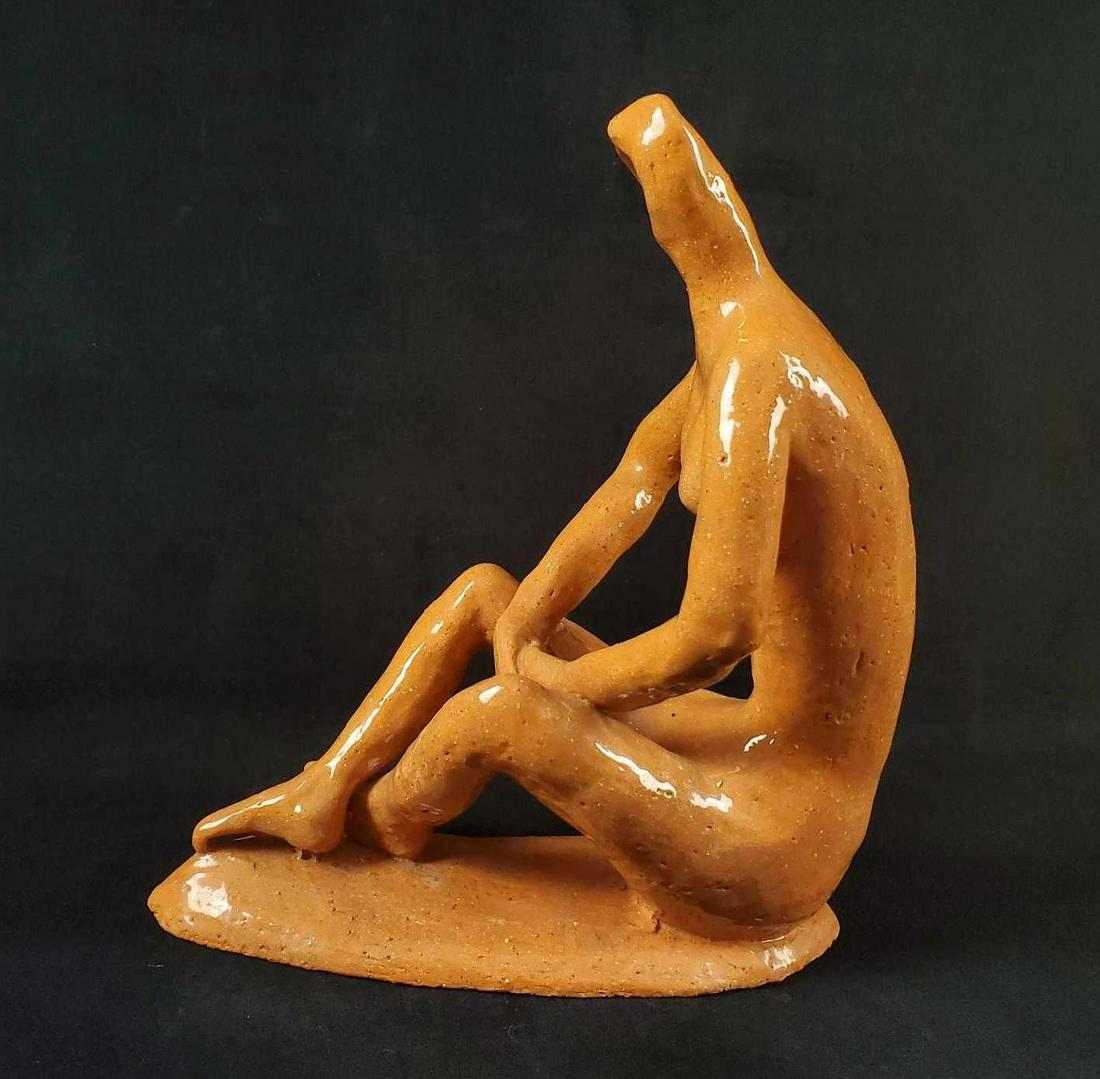 Vintage Abstract Glazed Earthenware Nude Woman: An abstract figure of a nude woman in a seated position. Made of naturally colored glazed earthenware. Signed on the bottom of base by the artist, illegible. Is approx 9" x 3" x 11". The figure is in 