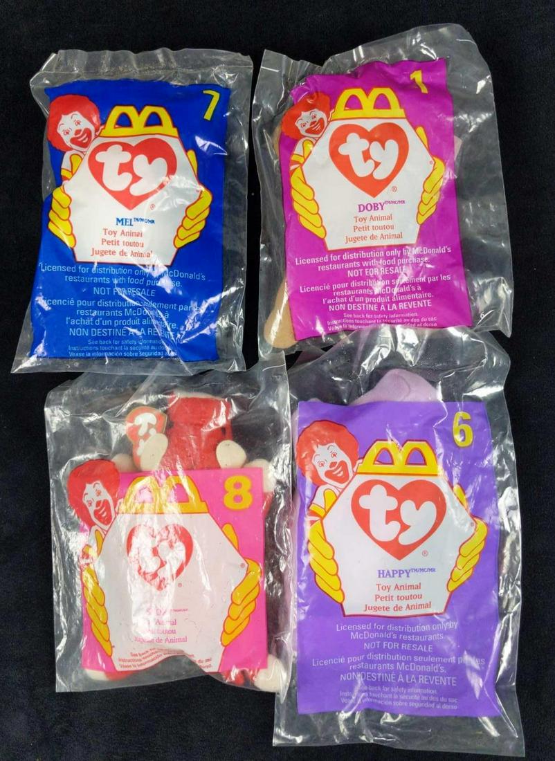 Four McDonalds Ty Teenie Beanie Babies A: This lot consists of: (1) Doby #1 1998. (1) Happy #6 1998. (1) Mel #7 1998. (1) Snort #8 1996. All come in their original packaging. Packages together are approx 5" x 2" x 9". Packages have shelf-wear