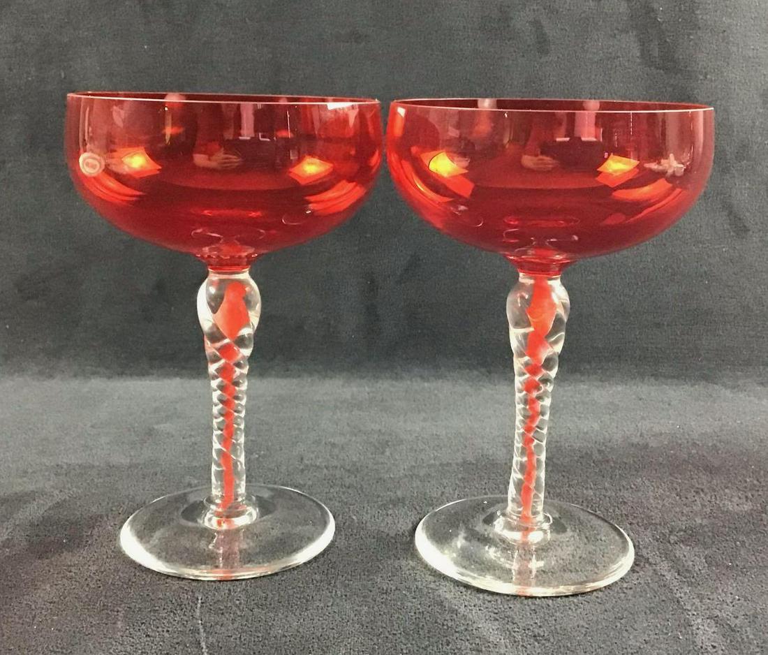 Lot of 2 Champagne Hand Blown Glasses: These appear to be hand blown champagne glasses due to their intricate details on the stem. They have a bright red bowl. The bright red color goes down into the middle of the stem. The stem has a beau