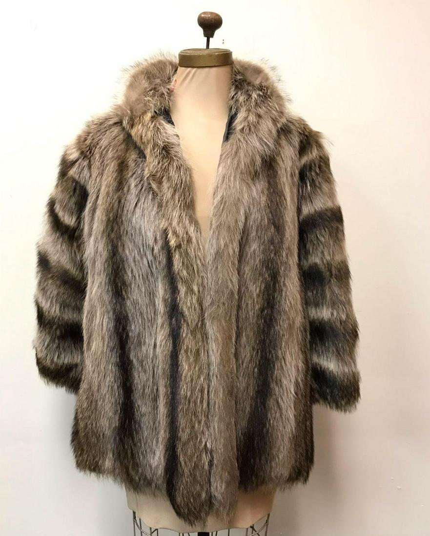 Raccoon Fur Coat by Pelliceria Pastacouldi: This mid length raccoon fur coat by Pelliceria Pastacouldi is in good used condition with no known damages. This coat features black linen interior, 1 hook and loop for closure as well as 2 outside po
