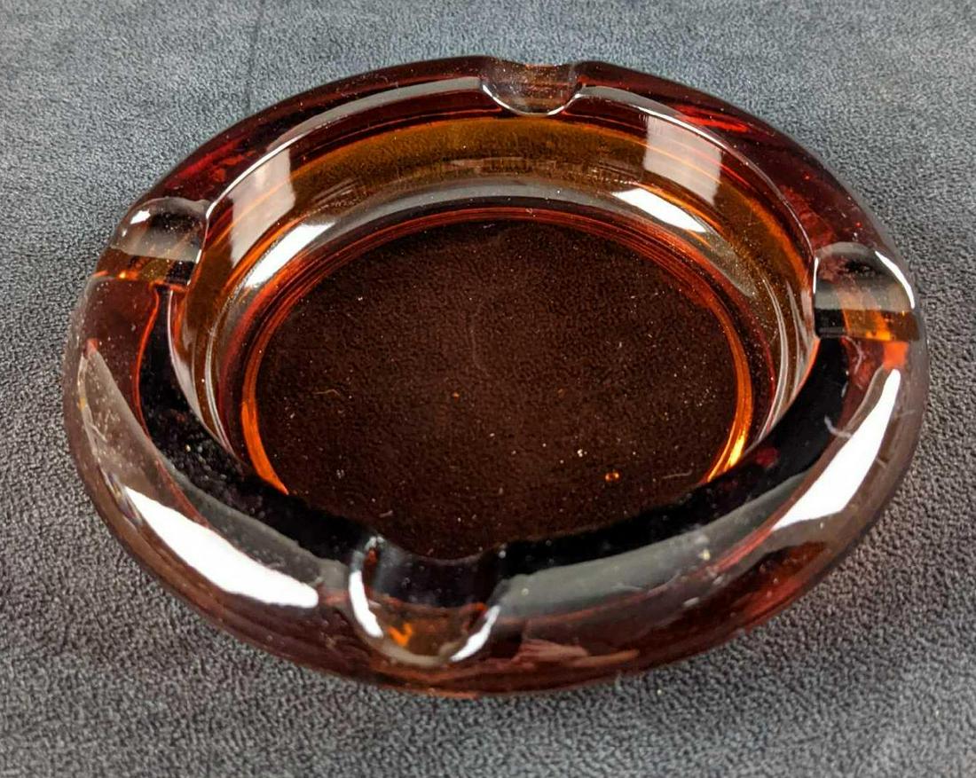Vintage Amber Glass Ashtray Cigar Cigarette: Solid glass amber ashtray. Date of creation and maker is unknown. Is approx 6" x 6" x 1" and is a good, vintage condition with some wear and smudges on the glass.