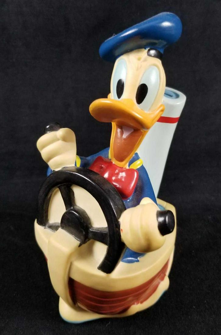 1994 Donald Duck Boat Toy Vinyl Coin Bank: Disney Donald Duck happily driving a tug boat put in the water plastic vinyl toy coin bank made by Just Toys, Inc. This toy bank is in good used condition and shows minimal signs of wear and tear like