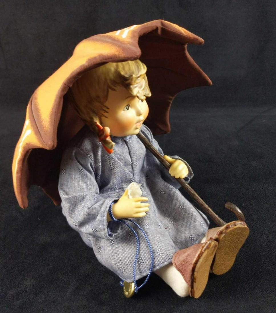 Vintage Goebel Hummel Girl Doll With Umbrella: Danbury Mint. Beautiful M.I. Hummel Doll, â€œUmbrella Girl.”The doll is about 8” high in a sitting position. Fine porcelain head, arms, and legs with a stuffed cloth body. Exquisitely