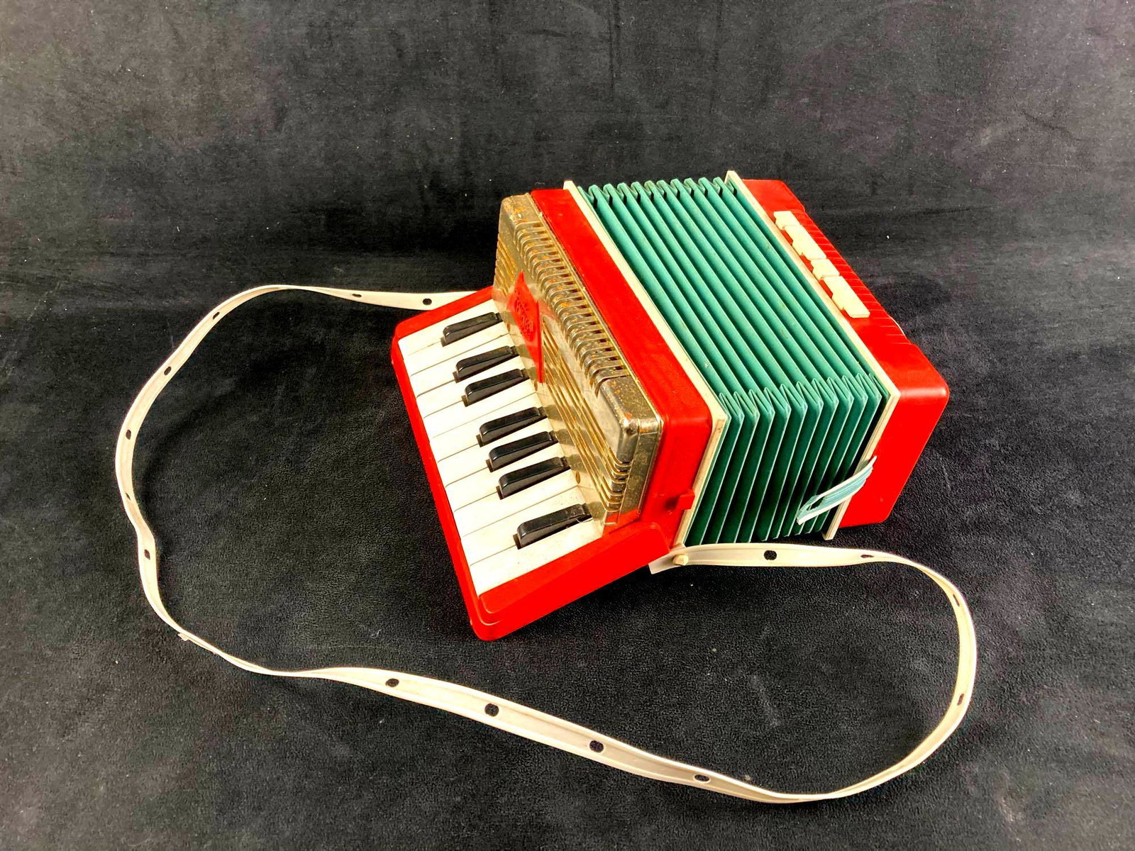 Child's Red Emenee Accordion: Up for auction is a recent estate acquisition, a red Emenee accordion. The accordion is red and the middle is a slight green color. This auction includes: (1) Child's Red Emenee Accordion Condition is