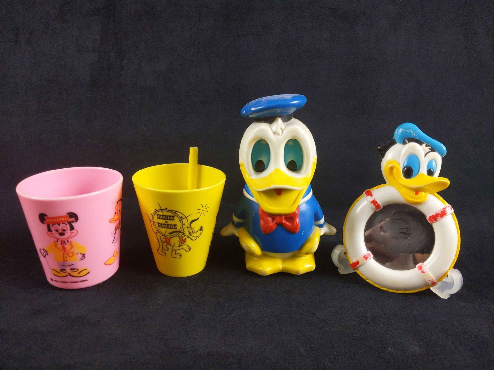 Vintage Collectible Donald Duck Items Lot of 4: 1) Vintage Disney on Parade sippy cup by American company Eagle. This plastic cup is yellow and has an attached straw. It features Pluto ,Mickey, Donald and one of his nephews in marching band attire.