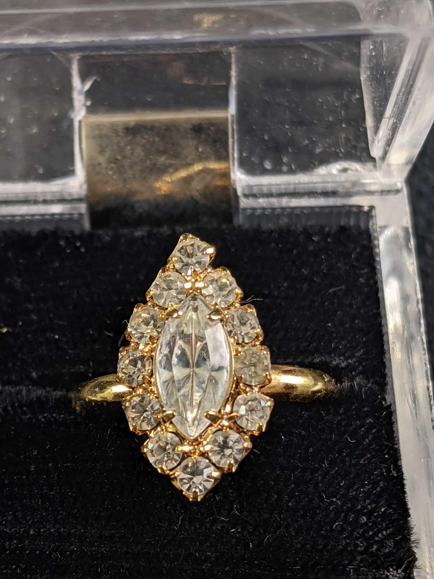 Gold Colored Fashion Ring In Box: Gold Colored Fashion Ring In Box This ring is in good condition, it is made of a gold-colored metal (not real gold). This ring is adjustable and comes in a clear box. All gems are intact and shiny. Bo