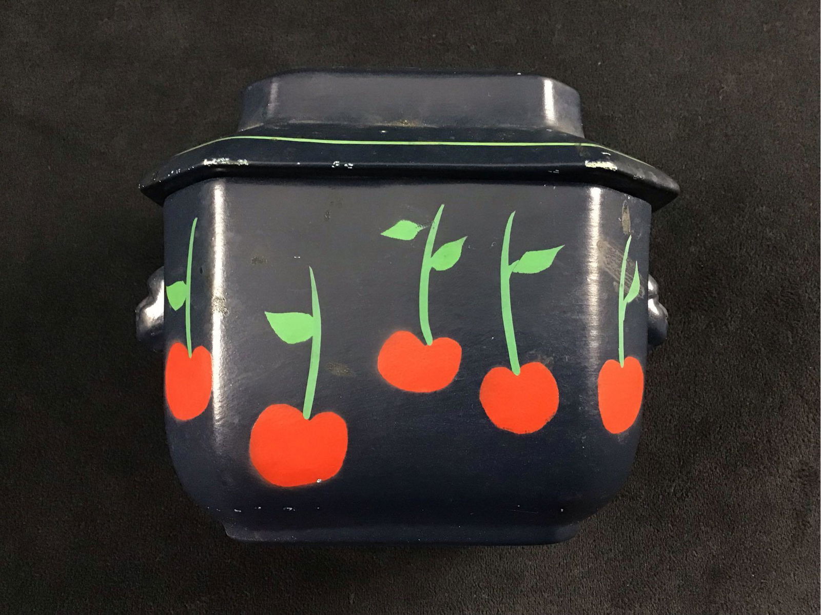 Decorative Vintage Circa 1900s Ceramic Pot with Lid: This is a very unique piece. It is a dark navy blue color with cherries around the front and back. The handles are shaped like faces making this an interesting piece. It is in good condition with some