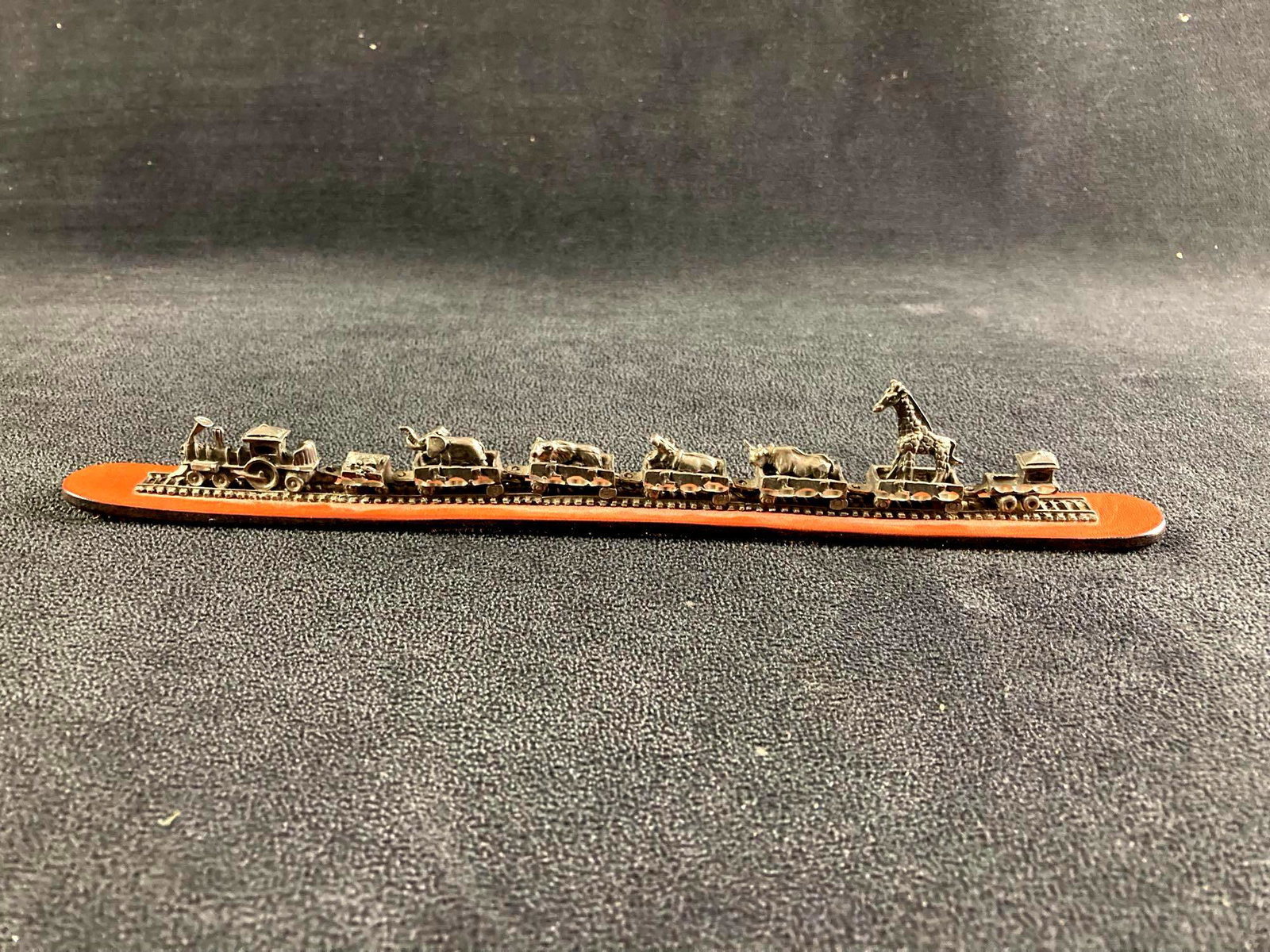Small Metal Train with Animals on Leather: This lot includes: (1) Small Metal Train with Animals on Leather Condition is used and see photographs for additional details. The toy train has five cars carrying animals and has a small locomotive a