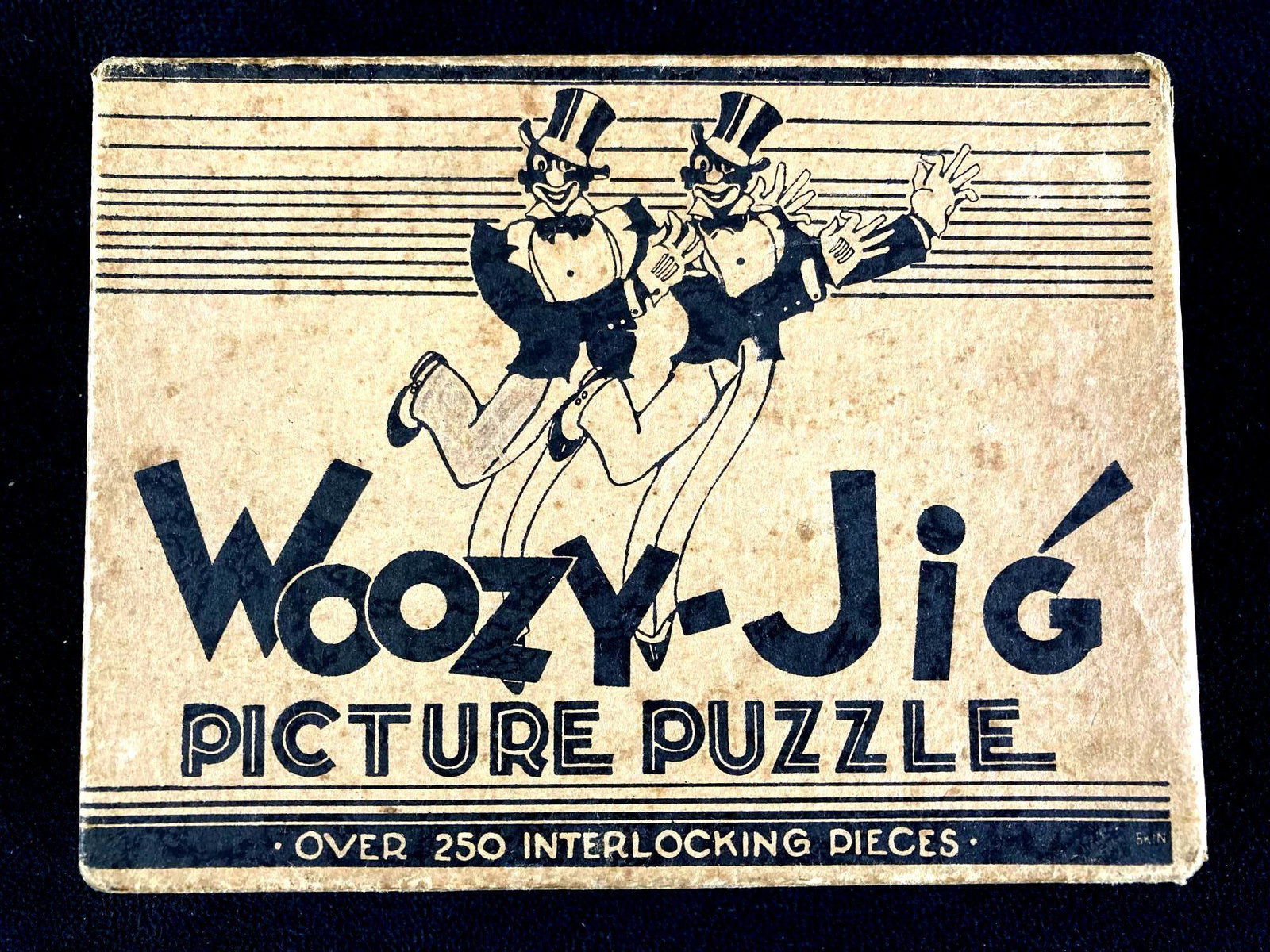 Woozy Jig Picture Puzzle Circa 1920's: This lot includes: (1) Woozy Jig Picture Puzzle Circa 1920's Condition is used and see photographs for details. The box has discoloration typical for age and the box has a semi loose bottom. The insid