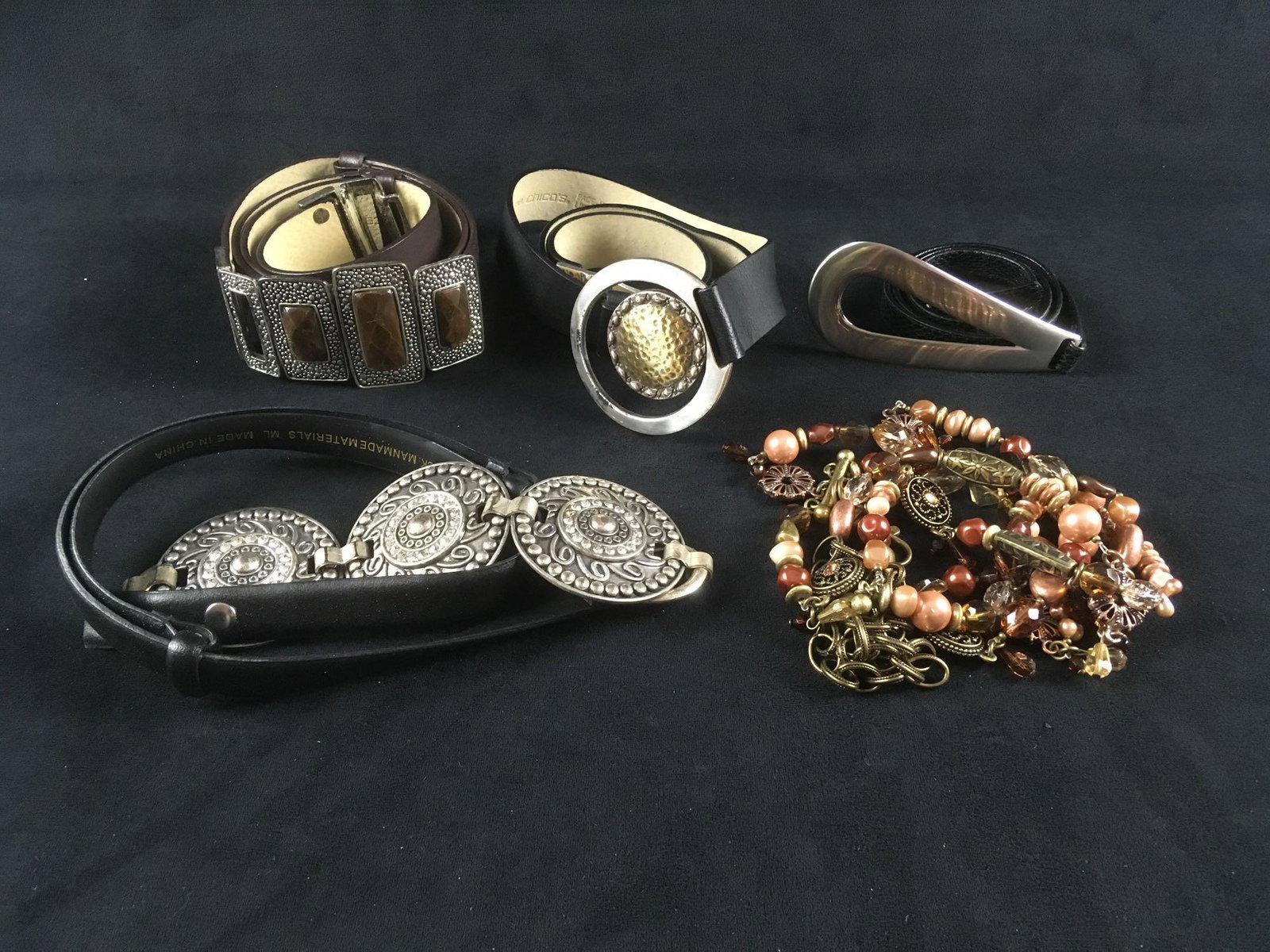 Collection of 5 Women's Designer Belts: Collection of 5 Women's Designer Belts; a collection that makes bold fashion statements. Lot consists of 1) wide brown leather belt with 4 pyrite-like faux stones in silver colored buckle, fair condit