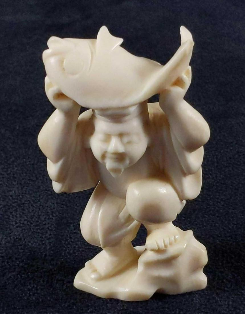 Vintage Hand Carved Bone Chinese Ebisu Figurine: Well made, a hand-carved figurine of Ebisu holding a mighty fish. The maker and date of creation are unknown. The figurine is in good, vintage condition with some light wearing. Figurine is approx 1 1