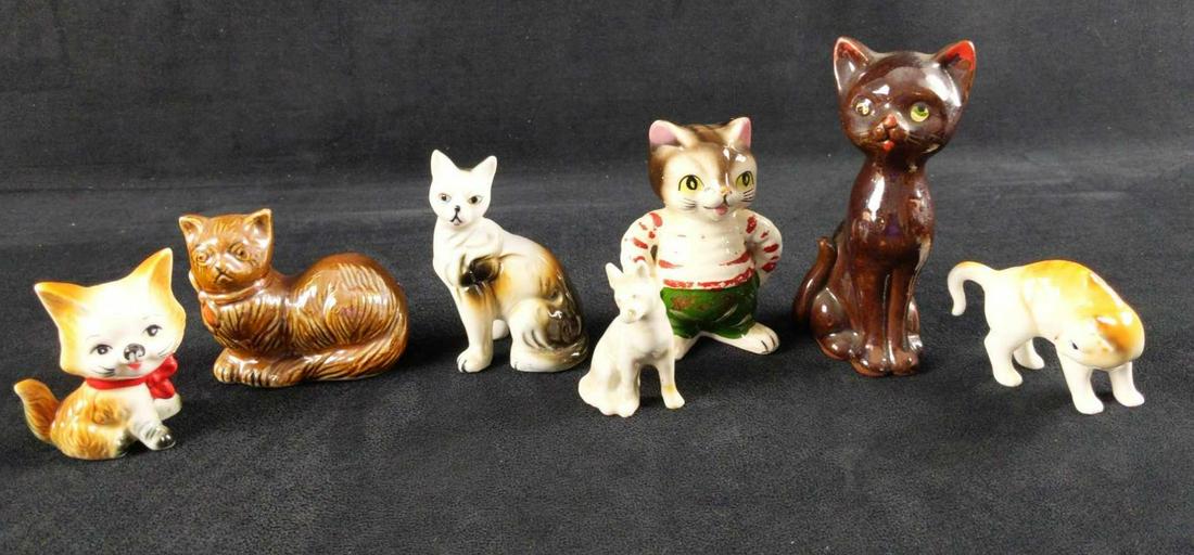 Vintage Ceramic Kitty And Dog Lot Of Seven: This lot consists of: (1) Ceramic Brown Kitty Figurine made in Japan.3" x 2" x 5 1/4". Has some wearing and paint-loss. (1) Ceramic Kreiss Cat wearing a red and white sweater. Is approx 2" x 2" x 4" C