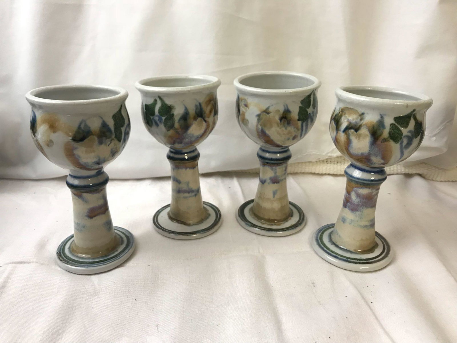 Ceramic Artisan Goblet Set;: Ceramic Artisan Goblet Set; This handmade set comes with a total of four goblets. Each have a very earthy eclectic design. They each measure at approx. 6 1/2" H x 3 1/3" D.
