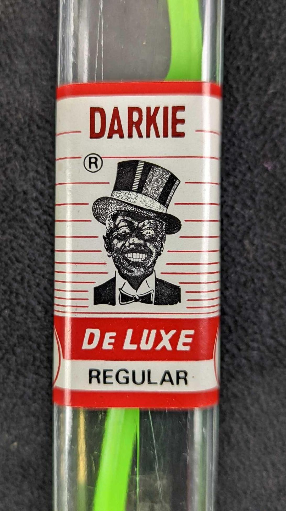 Vintage Black Americana Darkie DeLuxe Toothbrush: This is a sealed vintage toothbrush from Darkie, a brand that is now sold under the name "Darlie" in the US. The toothbrush is green with the outdated logo on the brush. Is approx 1" x 3/4" x 6 1/2" a