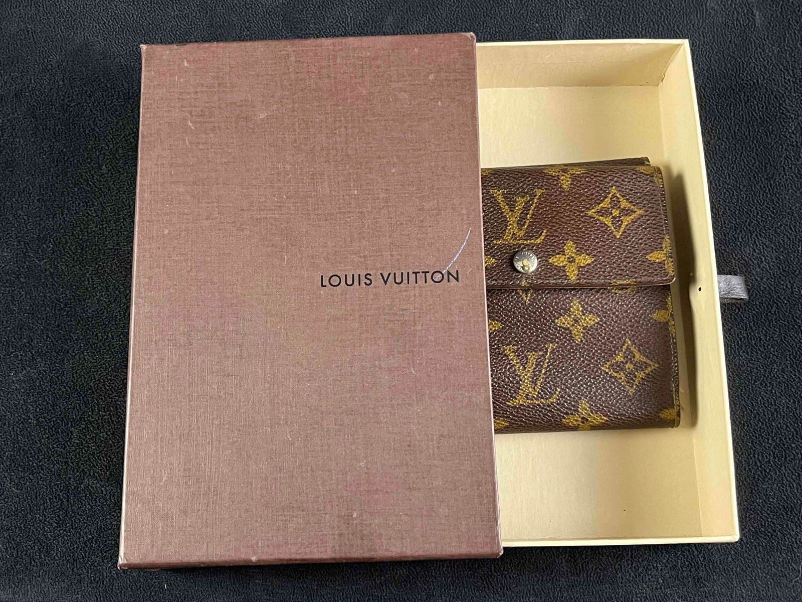 Vintage Louis Vuitton Wallet with Box: Vintage Louis Vuitton Wallet with Box Pictured is a Louis Vuitton wallet with a classic monogram design. The wallet is in used condition with some slight wear but no major blemishes or damage. Look at