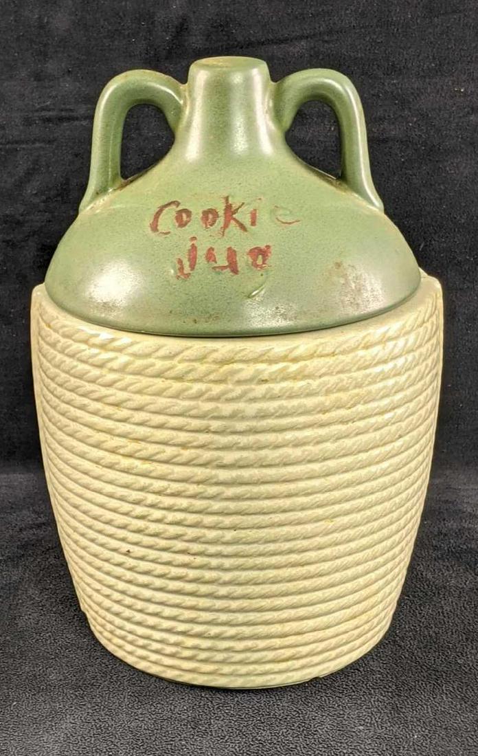 Vintage McCoy Cookie Jar Cookie Jug: Vintage McCoy Cookie Jar Cookie Jug This cookie jug is an old McCoy design of an old moonshine jug. This is in good condition with age wear and some wear on the bottom where it sits. There's a chip on