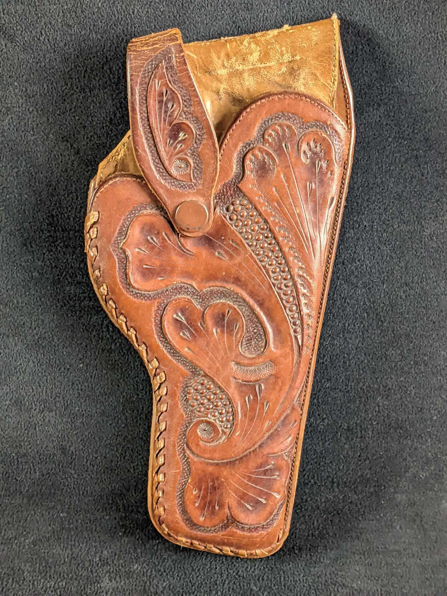 Brown Leather Gun Holster With Design Revolver: Brown Leather Gun Holster With Design Revolver This is a brown real leather holster for a revolver. This holster is in good condition with some wear but no major damage. The front has a great design. 